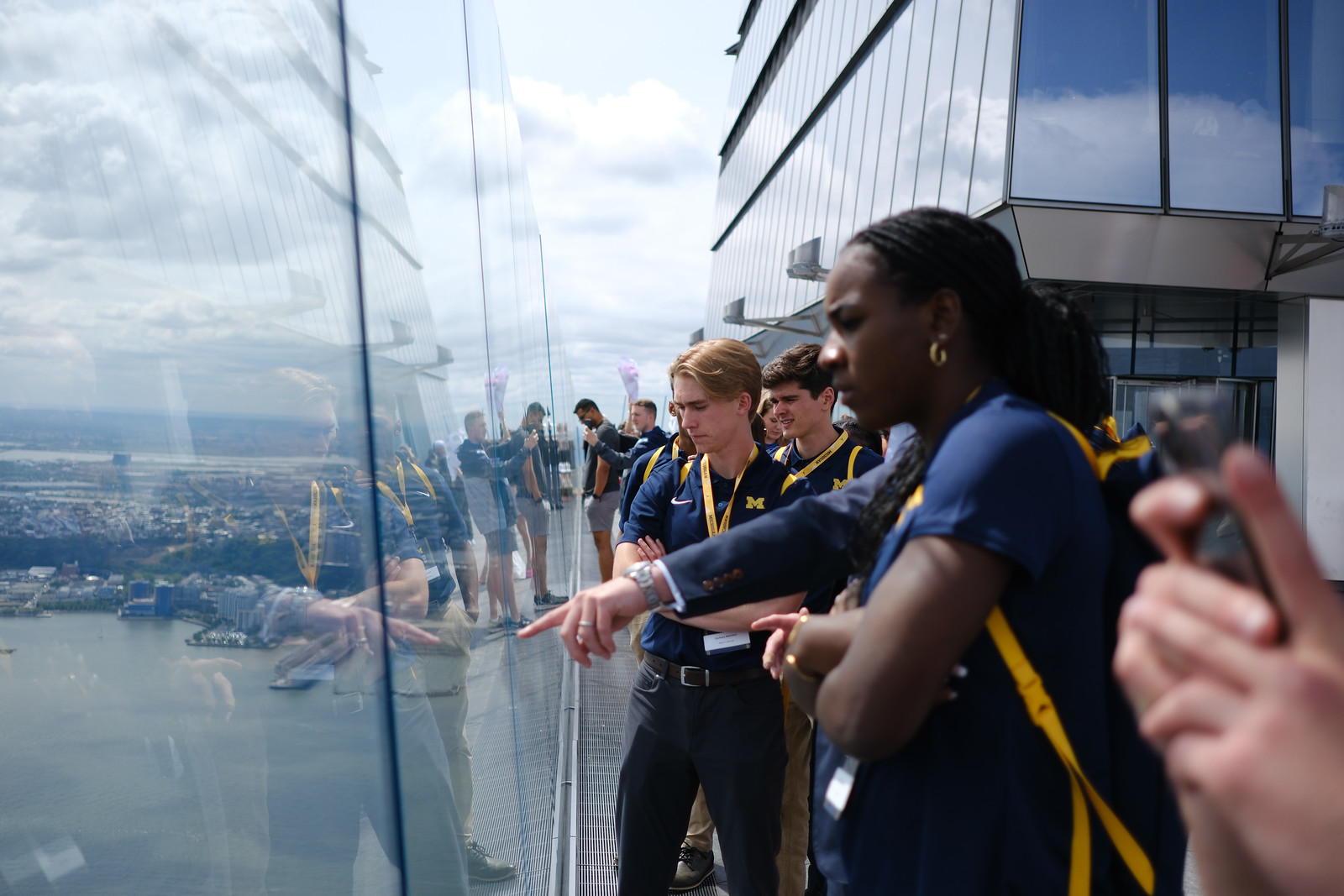 Visitors looking out over the city through a glass observation deck