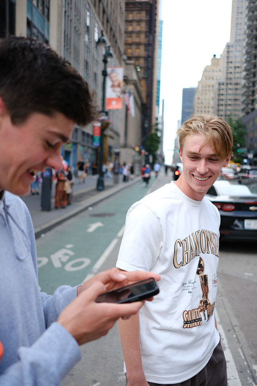 Friends sharing a laugh on a city sidewalk