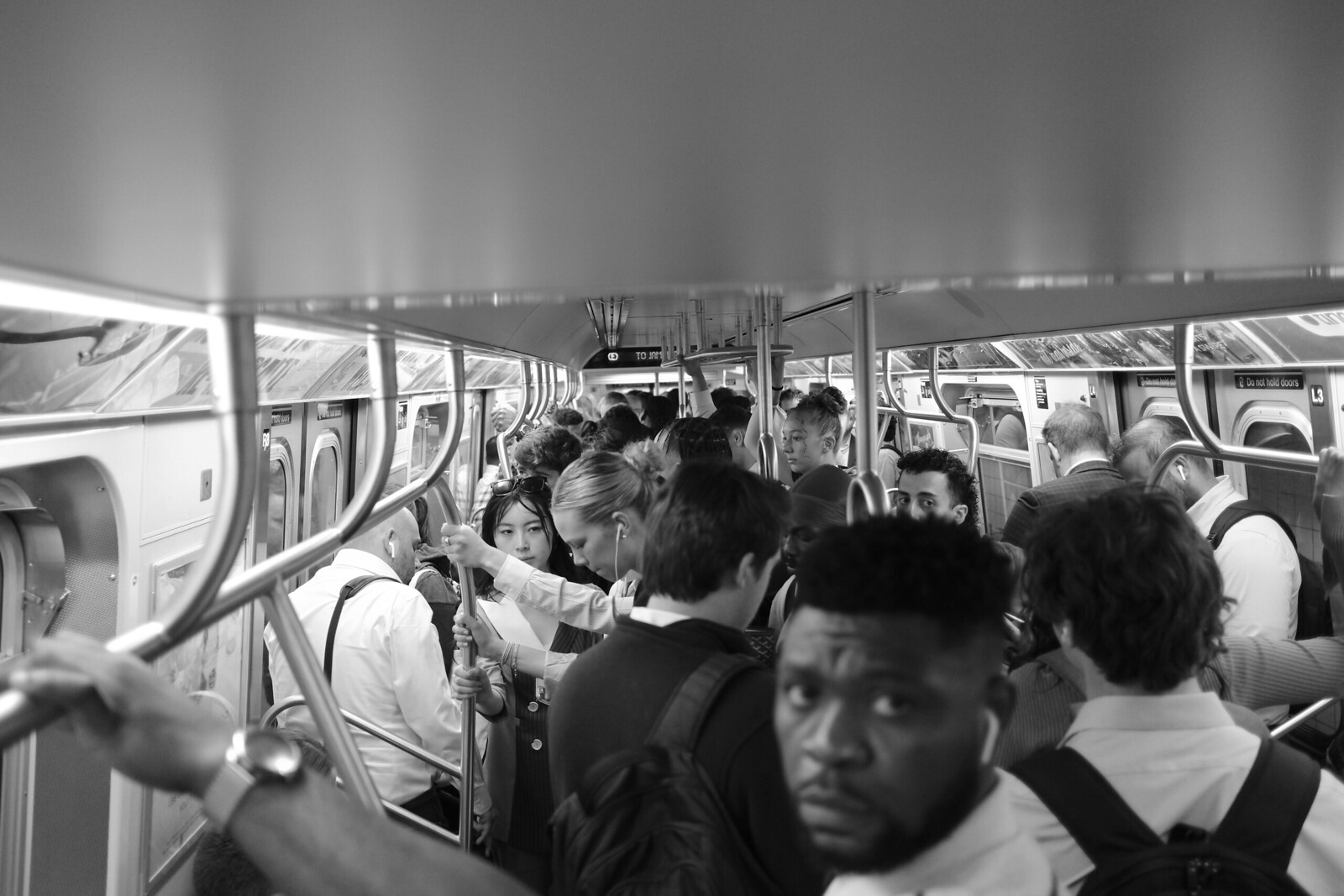 Black-and-white photograph of passengers inside a subway car