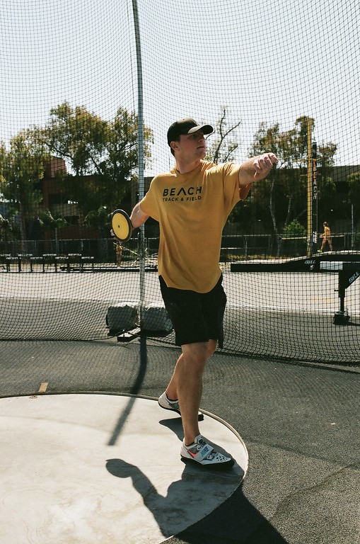 An athlete in a yellow uniform preparing a throw