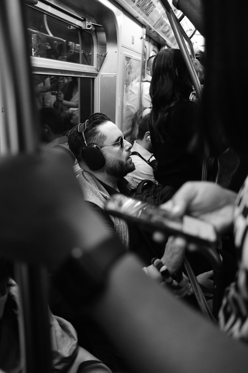 A black-and-white candid photograph of passengers on a subway
